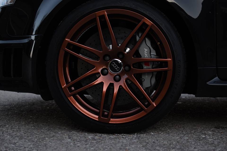 Close-up van een bronskleurige velg op een zwarte Audi