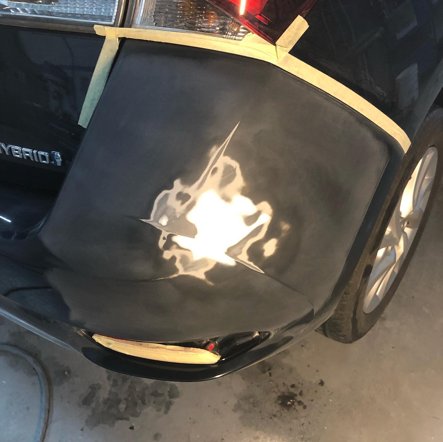 Zwarte Toyota Hybrid, bumperhoek afgeplakt en geschuurd