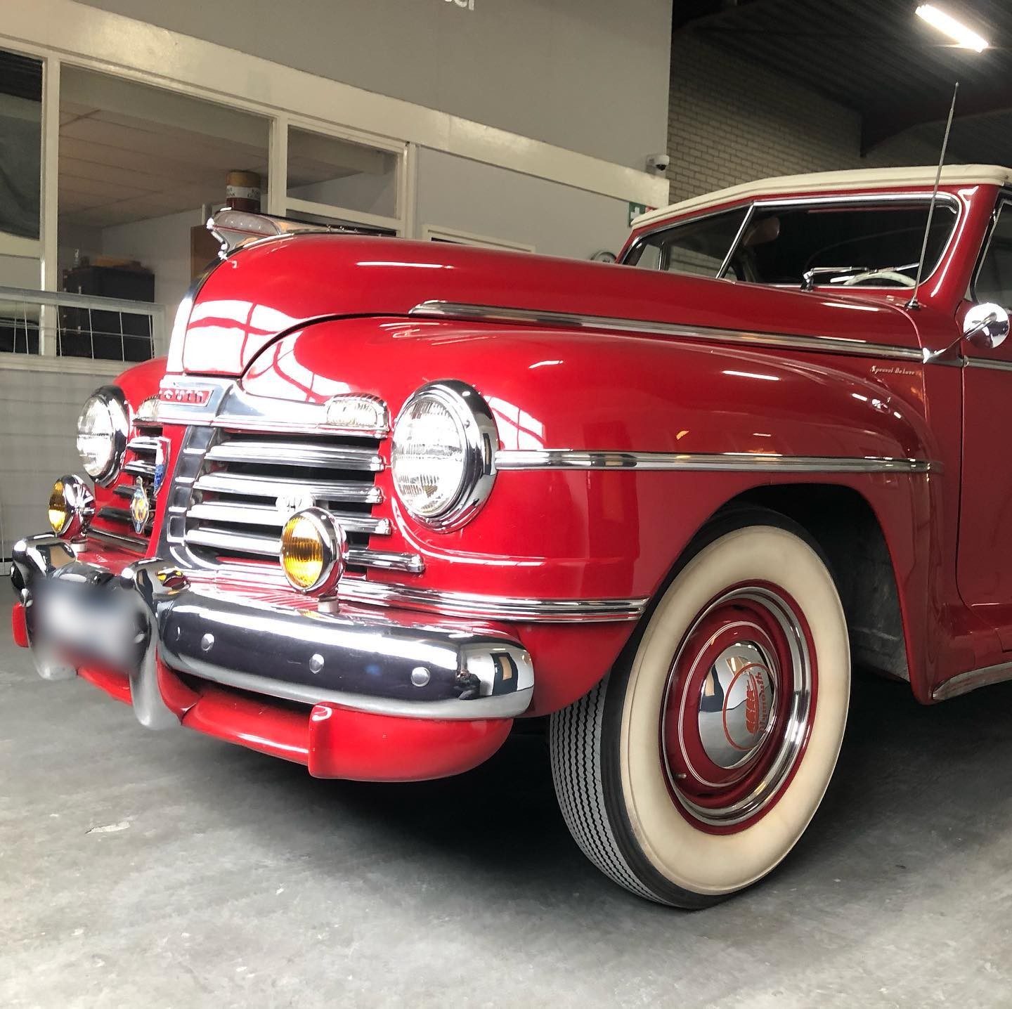 Rode klassieke Plymouth met witte banden in de werkplaats